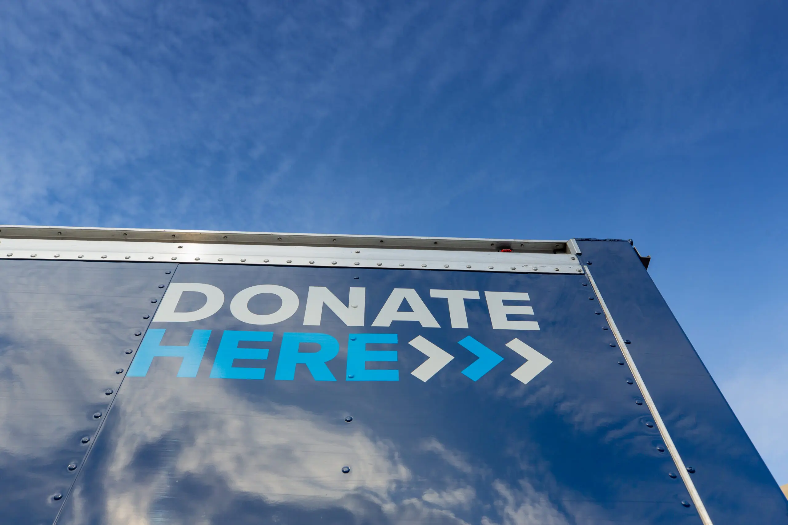Looking up at the back of a Northwest Center blue truck with the words Donate Here.