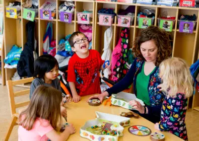 Kids and an educator at a table in the learning center