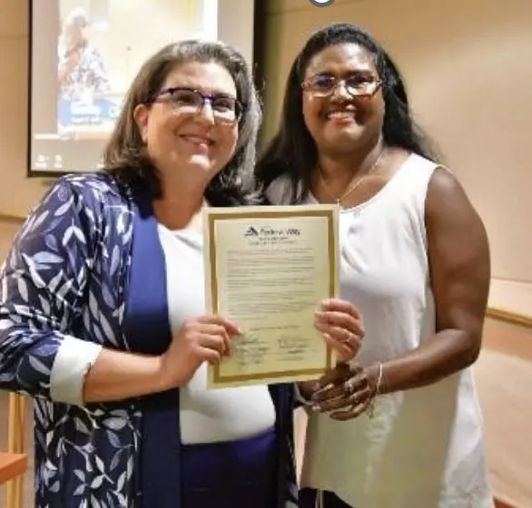 Jennifer Ramirez Robson, Chief Program Officer for Northwest Center and Council Member Lydia Assefa-Dawson. holding the Disability Pride Proclamation document at the Federal Way City Council meeting in August.