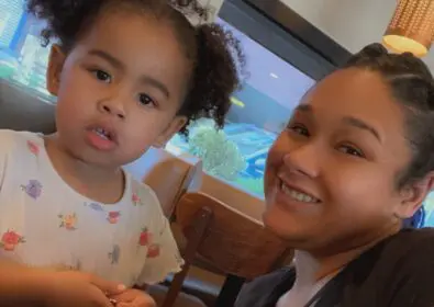 Mom and Daughter sitting closely together at a table smiling
