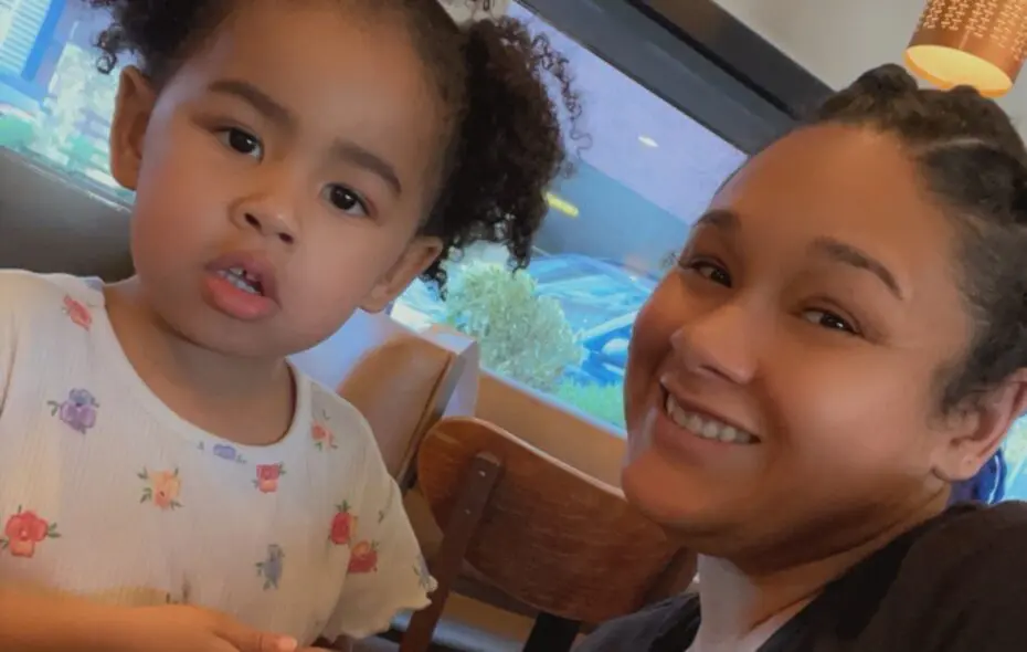 Mom and Daughter sitting closely together at a table smiling