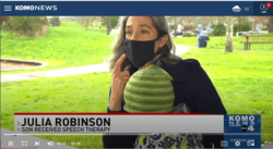 Woman wearing a mask on the news. Julia Robinson, son received speech therapy.