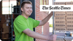 Man pushing a cart with boxes. The Seattle Times.