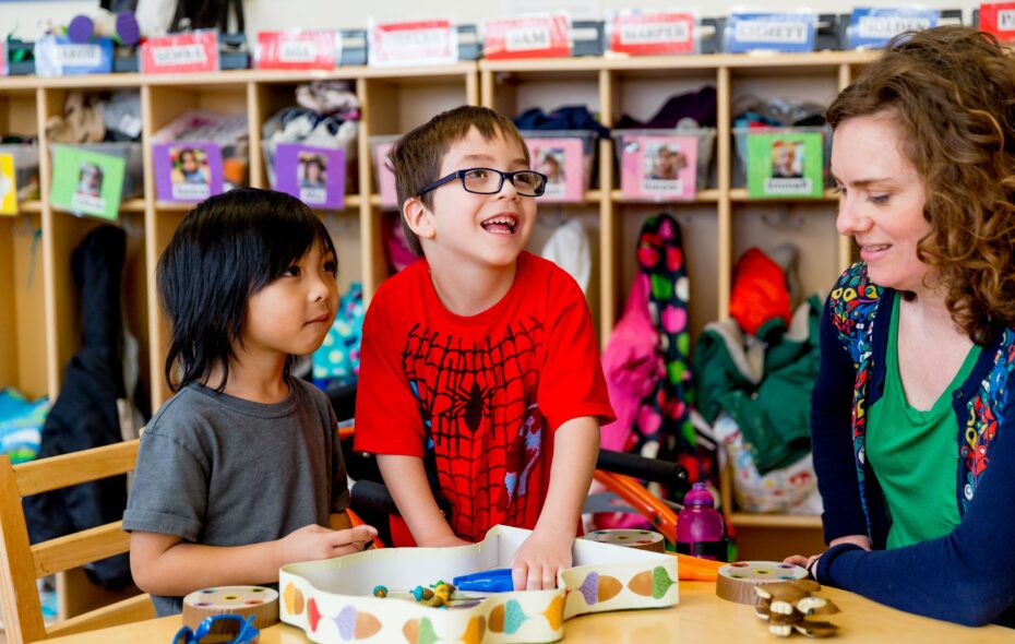 Two boys and a teacher play a game.