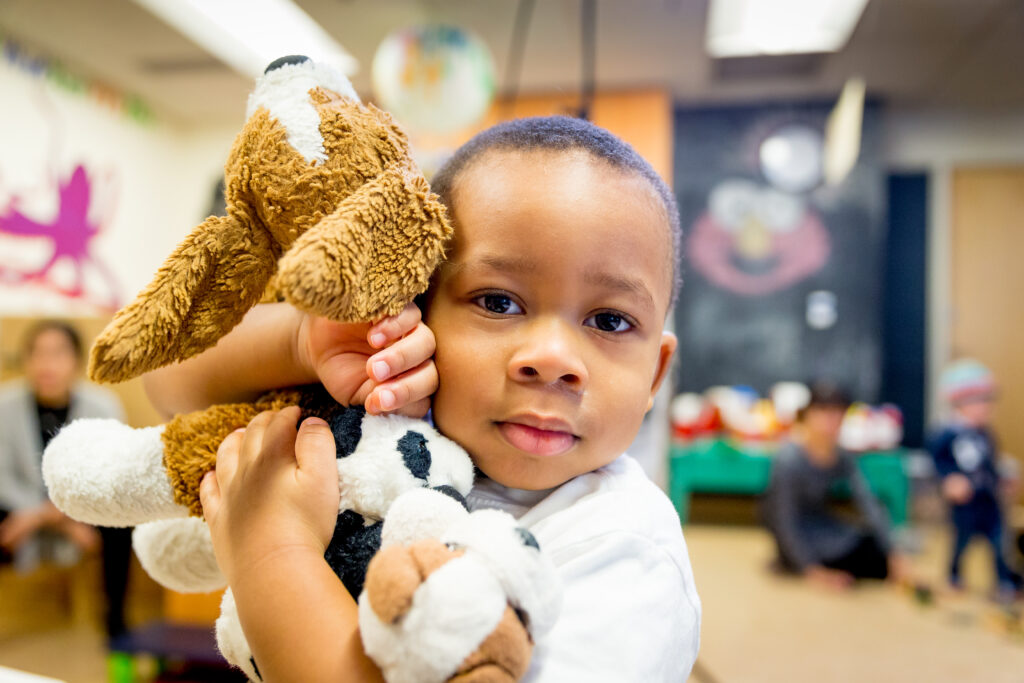 Kid hugging a teddy bear.