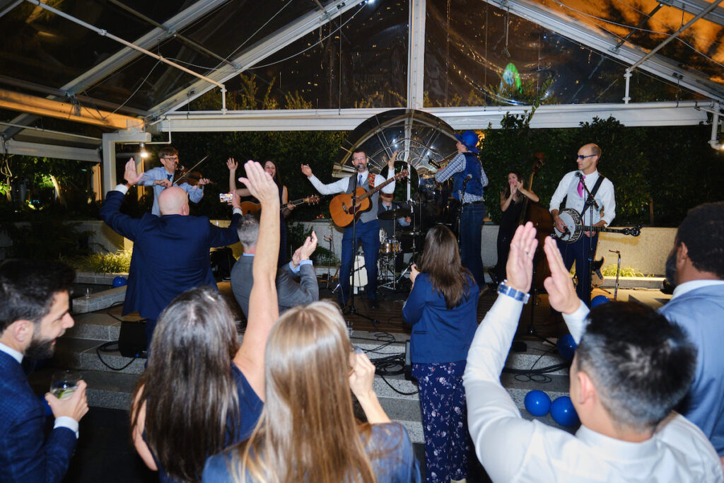 Small crowd in front of a band playing live music.