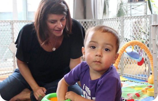 Woman looking at child sitting down.