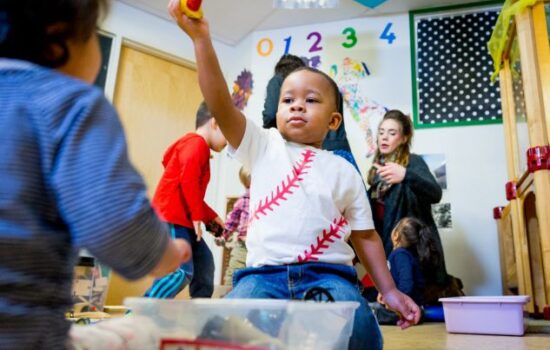 Kid playing with a toy in a classroom.